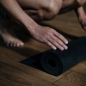 Close-up of a rolled pink yoga mat on floor.